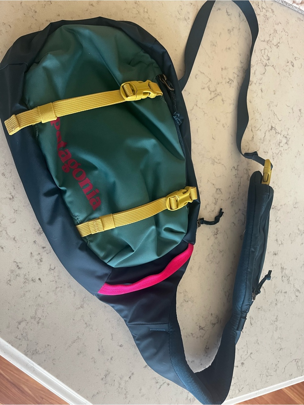 Patagonia Dark Green Sling Belt Bag with Yellow Straps and Pink Accent